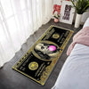 A rectangular black and gold banknote pattern anti-slip floor mat placed on a gray floor next to a white window.