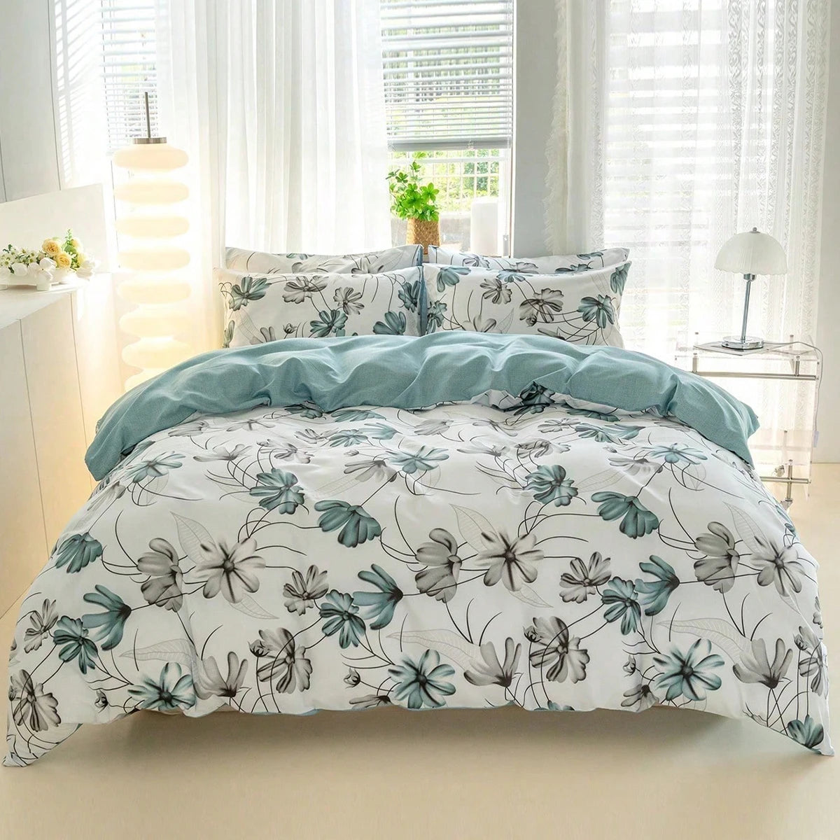 A white duvet cover set with teal and grey watercolor floral print displayed on a bed.