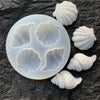 A set of white shell and starfish fondant molds for cake decorating, showing various sea creature shapes.