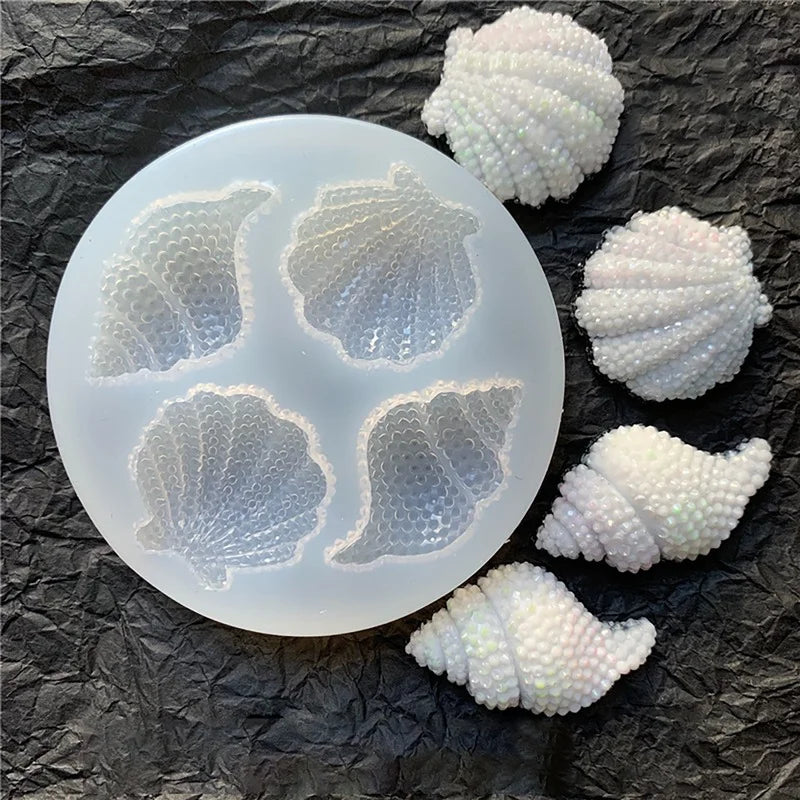 A set of white shell and starfish fondant molds for cake decorating, showing various sea creature shapes.