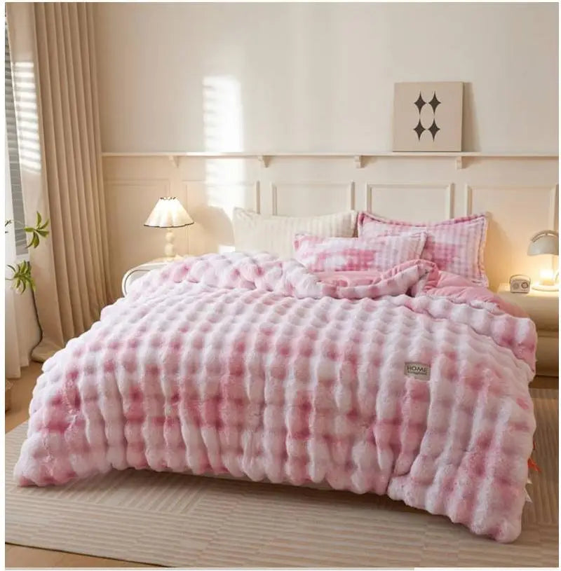 A pink checkered plush winter comforter draped on a bed with light wood accents and sheer curtains.