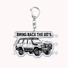 A silver metal key ring attached to a model of an off-road truck.