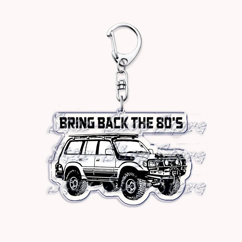 A silver metal key ring attached to a model of an off-road truck.