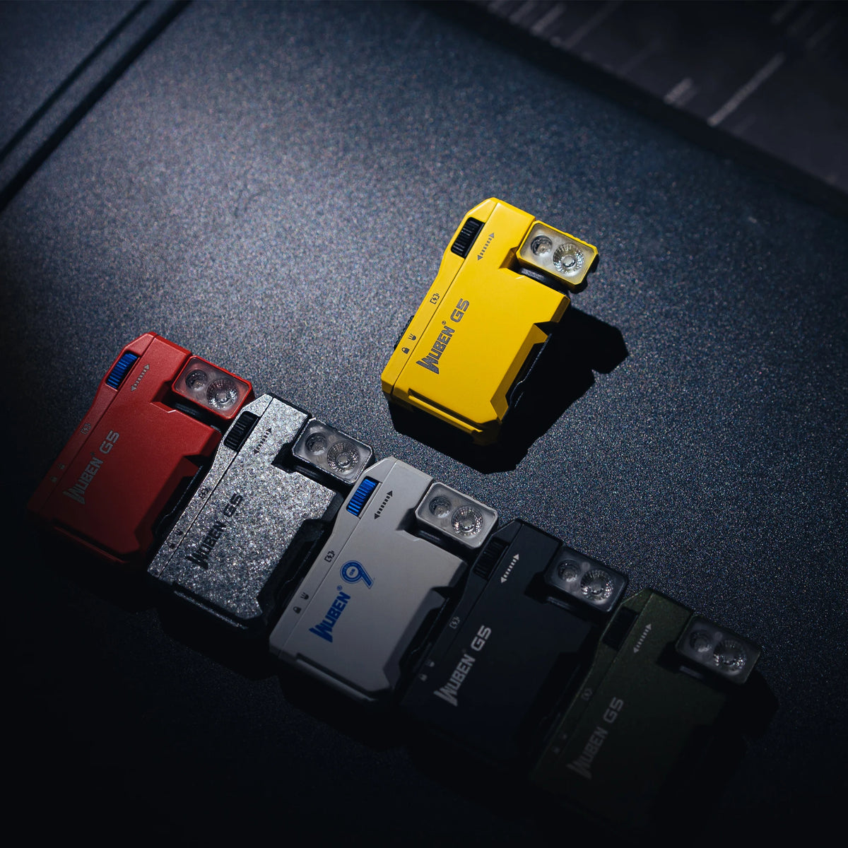 A collection of Wuben G5 compact rechargeable flashlights in various colors, including red, silver, and yellow, resting on a 