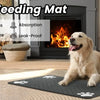 A golden retriever dog lies on a black pet feeding mat in a living room setting.