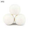 Three white natural wool dryer balls are shown against a white background.