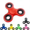 A collection of colorful smooth-spin fidget spinners in blue, yellow, green, and pink.