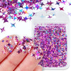 A hand holds a clear plastic container filled with purple and pink holographic star sequins for resin crafts.