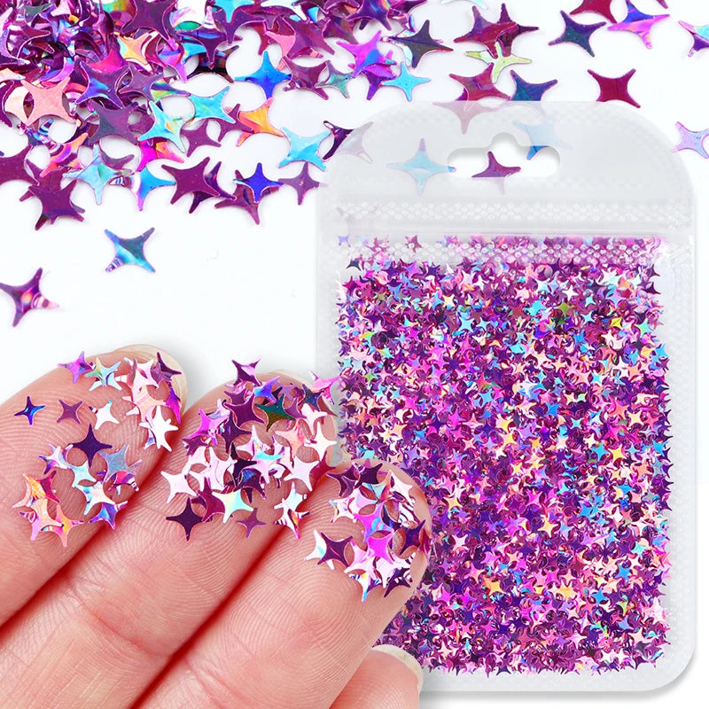A hand holds a clear plastic container filled with purple and pink holographic star sequins for resin crafts.