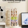 A clear rotating storage box filled with small collectible figures and keepsakes on a white surface.
