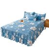 Jupe de lit à imprimé floral bleu clair avec volants et fleurs blanches sur un lit.