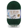 A skein of dark green milk cotton blend yarn with a label featuring Chinese and English text.
