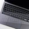 A close-up view of a transparent TPU keyboard cover for a MacBook, showing the keys and surrounding surface.