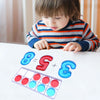 A child is looking at a math activity showing the equation 8 minus 5 plus 3, with corresponding colored counting tiles.