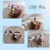 A clay art set featuring 36 colors of ultra light air dry clay for kids with modeling tools displayed on a beige woven mat.