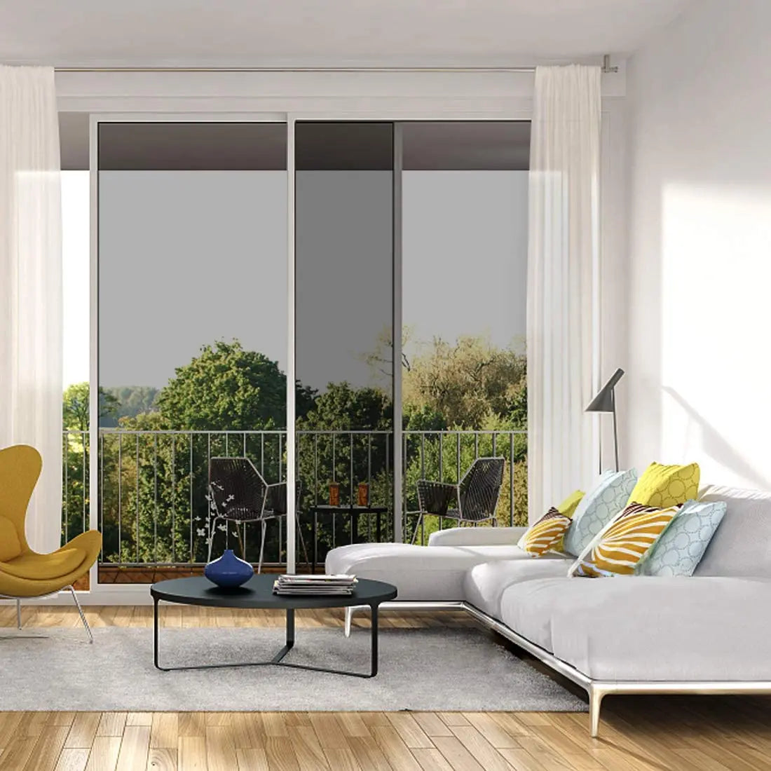 A modern living room interior showing a large glass door with privacy film, flanked by white curtains and a wooden floor.