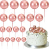 Ein Set aus 20 rosa und goldenen Kugle-Konditordekorationen auf Stäbchen