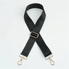 Black nylon bag strap with a gold buckle shown diagonally against a white background.
