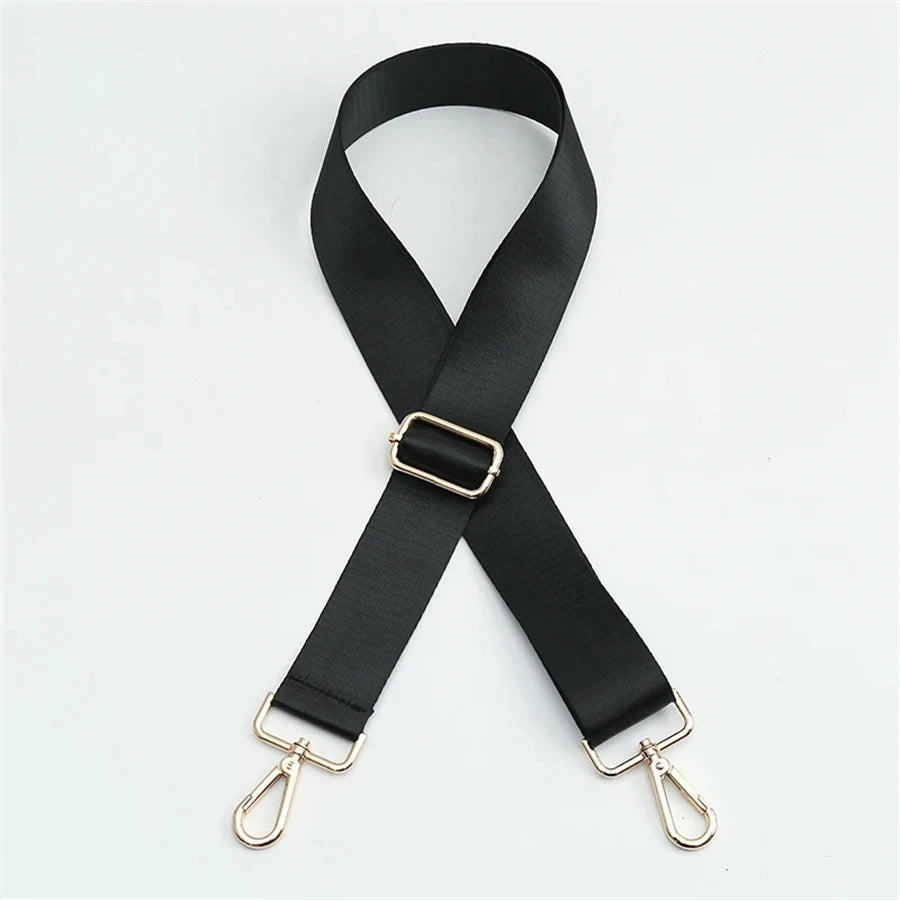 Black nylon bag strap with a gold buckle shown diagonally against a white background.