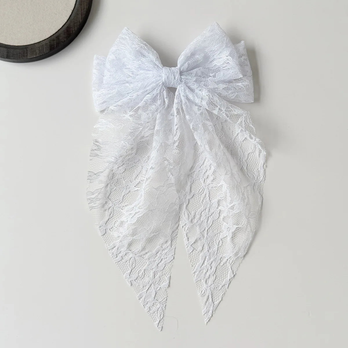 White lace bow hair clip accessory with delicate floral pattern