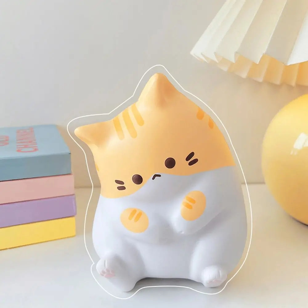 A white and orange cartoon cat squishy stress relief toy sitting on a white surface.