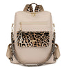 Beige Reise-Rucksack mit Leopardenmuster-Klappe und goldfarbenen Details.