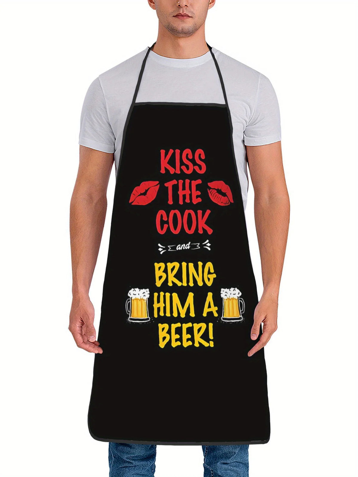 A man wearing a black chef apron with white text that reads Kiss the Cook and Bring him a beer