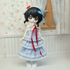 An articulated BJD collectible figurine with black hair, a white and blue checkered dress, and a red ribbon, standing in a li
