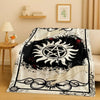 A black and white graphic throw blanket featuring a sun design and occult symbols.