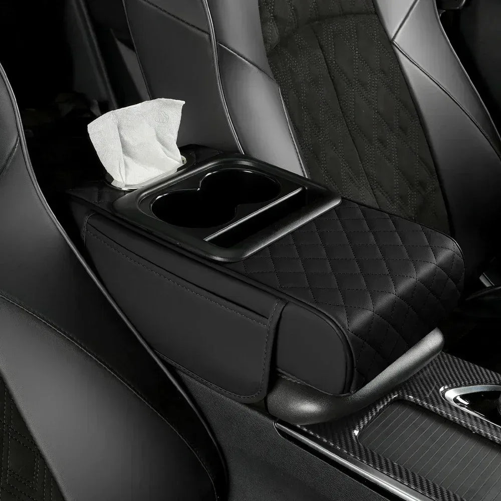 A black car center console armrest with storage and a cup holder, featuring a quilted texture.