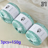 Three balls of teal glitter yarn labeled MuYuan Frost Words for knitting and crafting