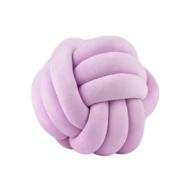A round, light purple knitted velvet throw pillow with a textured, knotted surface.