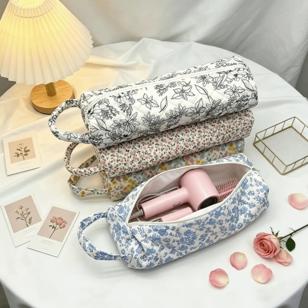 A light blue quilted cotton storage bag with a handle is shown next to various floral-patterned fabric items on a white table