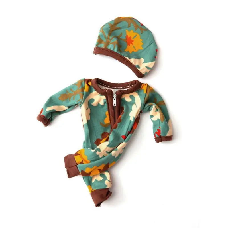 A knitted outfit for a baby doll featuring a teal and orange floral print jumpsuit and matching hat.