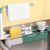 A white dish drying rack with a hanging towel and a slotted tray for dishes, placed in a kitchen sink.