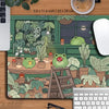 A large extended desk mat featuring a kawaii frog and lush green nature design on a wooden surface.