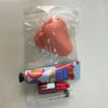 A pink squishy pimple popper fidget toy is shown inside a clear plastic bag next to related tools.