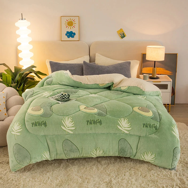 A light green plush throw blanket with leaf and oval patterns is displayed on a bed in a bright room.