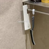 A white and gray multifunctional crevice cleaning brush set mounted on a wall panel.