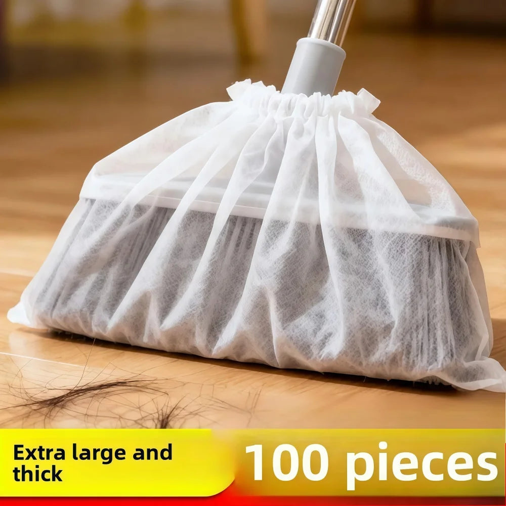A white disposable broom cover made of sheer fabric is shown on a wooden floor.