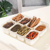 A clear plastic container holds various dried spices and herbs in separate compartments for portable use.