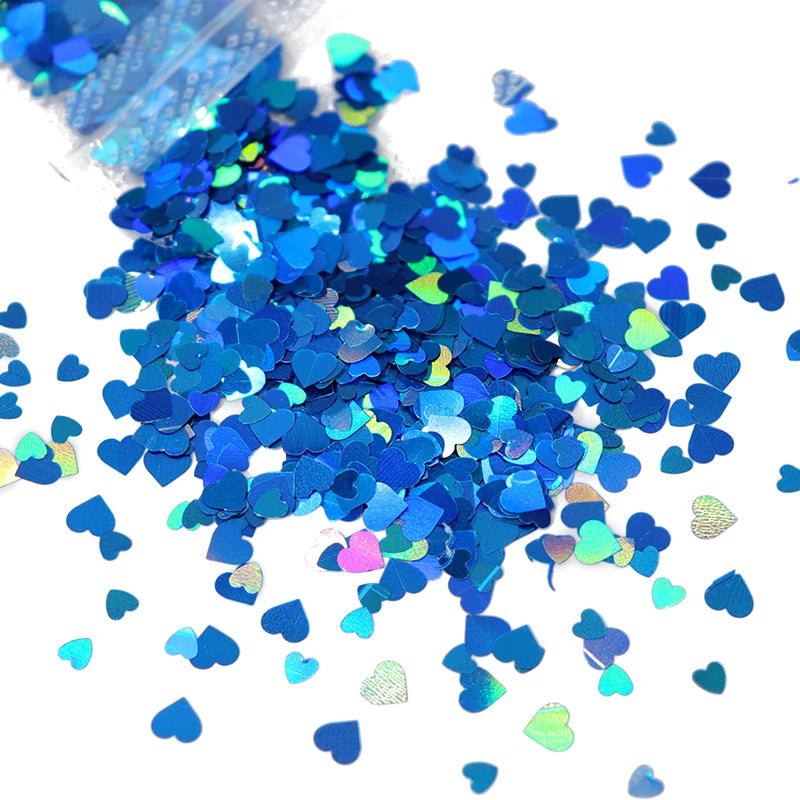 A pile of shiny holographic star sequins in various shades of blue and green for resin crafts.