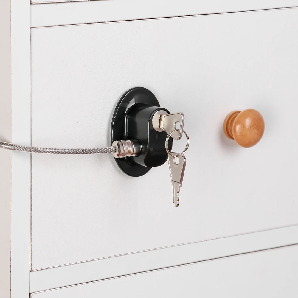 A black cabinet lock with a key is mounted on a white door, featuring a silver chain and a brass key.