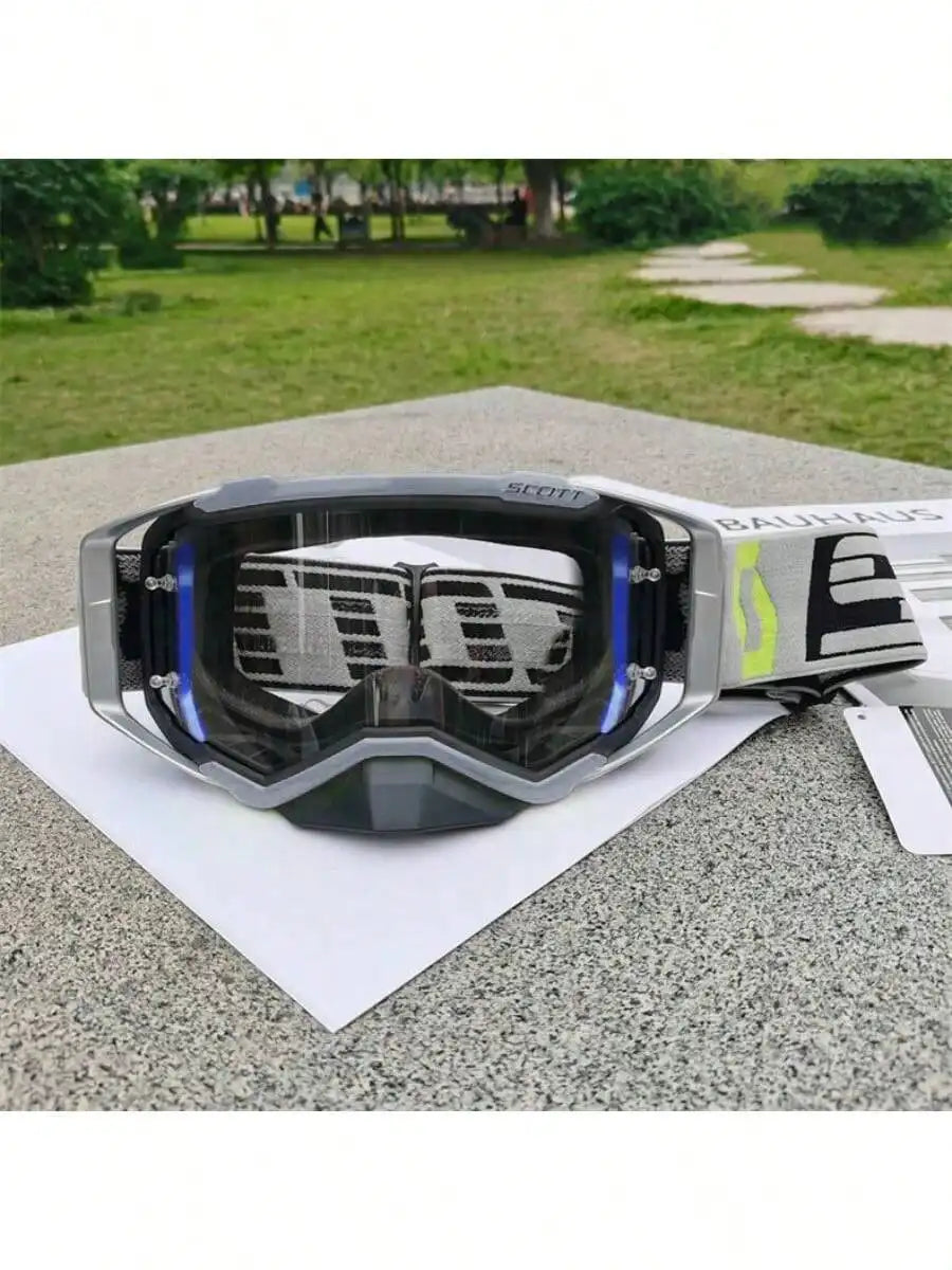 A pair of SCOTT Bauhaus motocross goggles resting on a white paper outdoors.