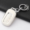 Silver Honda key fob cover with a decorative chain attached, resting on a black surface.