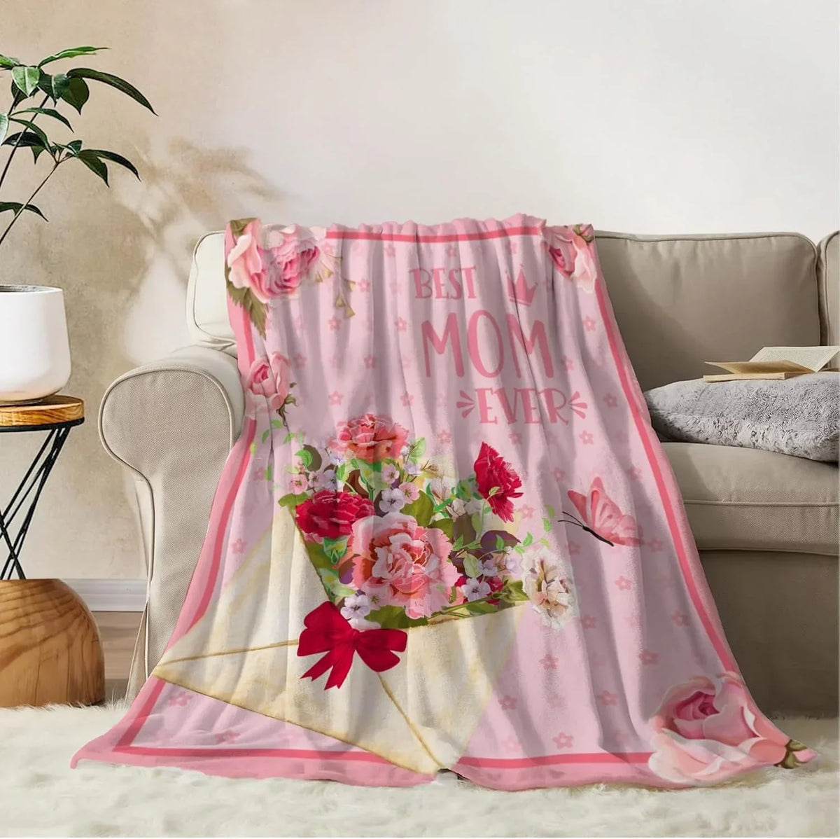 A pink floral fleece throw blanket featuring pink and red roses and butterflies on a light pink background.