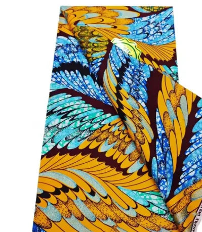 Close-up of a vibrant yellow and blue African wax print fabric featuring intricate feather patterns.