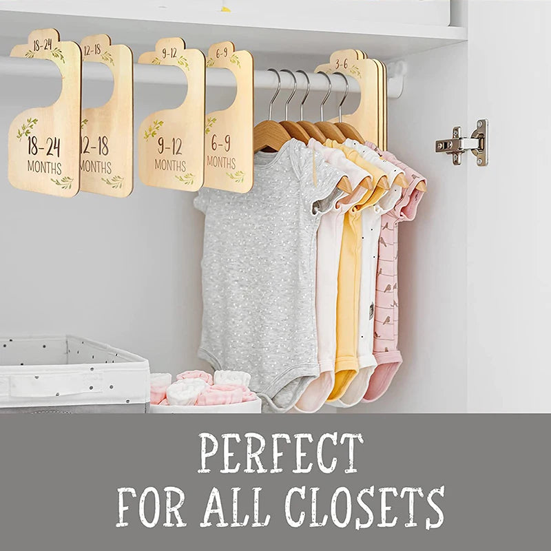 A set of eight wooden baby closet dividers with size labels for organizing clothes.