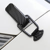 Black carbon fiber rear trunk locking buckle set mounted on a white car surface.
