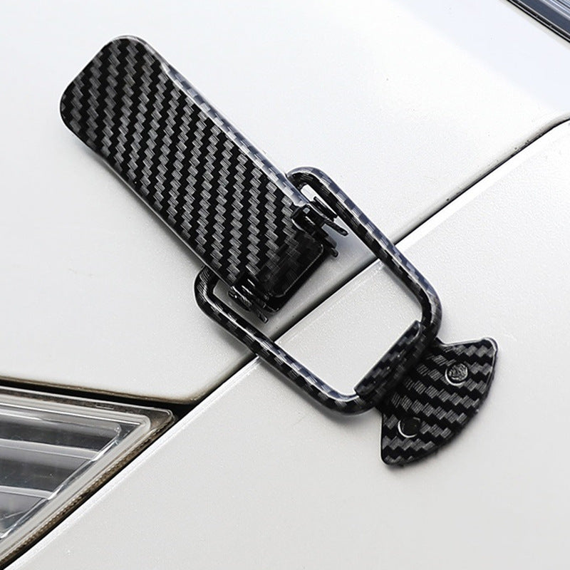 Black carbon fiber rear trunk locking buckle set mounted on a white car surface.